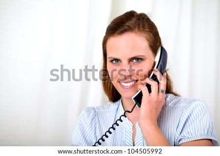 Close up portrait of a beautiful blonde girl smiling on phone