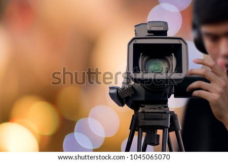 Camera Operator recording event with video camera Royalty-Free Stock Photo #1045065070