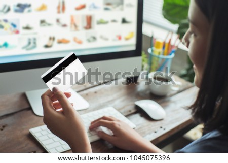 Women are buying online from the website. She is going to take a credit card.