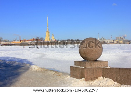 St. Petersburg Cityscape Winter View from Granite Neva River Embankment and Peter and Paul Fortress on Background in Russia. Panoramic Landscape View of Frozen Neva River in Downtown Saint Petersburg.