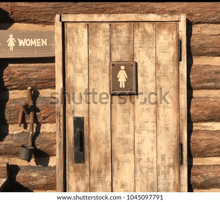 Woman rest room sign on grunge wooden door