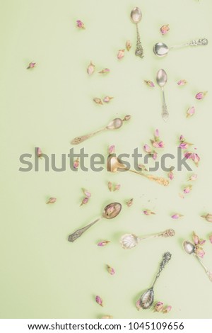 Pattern of antique teaspoons and dried roses top view