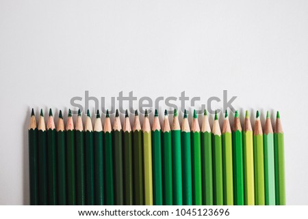 Row of green coloured pencils  lying one to another in a line. Different shades of green. Concept of taking care of ecology and environment.