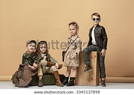 Two beautiful teen girls and boys on a pastel studio background. Stylish young teen girls posing at studio. Safari style. Classic style. Teen and kids fashion concept. children's fasion concept Royalty-Free Stock Photo #1045137898