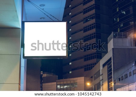 Lightbox mounted on the wall of a building in the business district at night