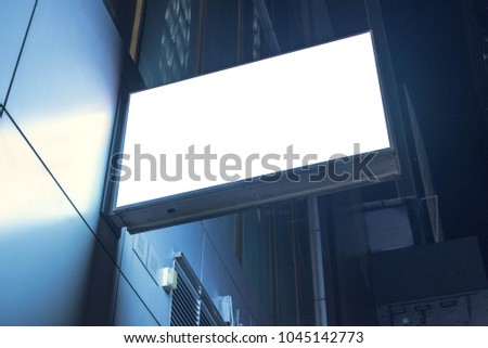 Lightbox mounted on the wall of a building in the business district at night