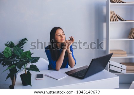 modern pensive woman, office worker, waiting for inspiration, looking away while sitting at her workplace in office