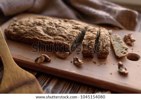Homemade baking dietary bread with nuts, low key lighting, food picture in a rustic style.