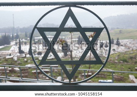 Ancient Jewish cemetery in Safed Tzfat seen through a Star of David decoration of the fence. Concept of Jewish history, Jewish heritage. Jewish symbol