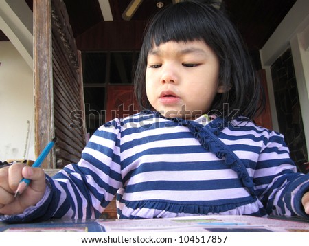 little girl drawing with pencils