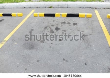 the asphalt floor of parking lot with concrete wheel stop 