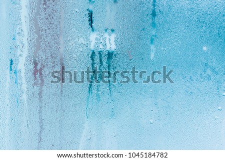 Background of natural water condensation, window glass with high air humidity, large drops drip. Collecting and streaming down