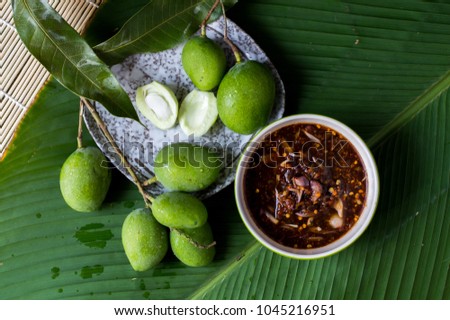Green mango with sweet fish sauce on green leaf, Thai popular food, Selective focus Royalty-Free Stock Photo #1045216951