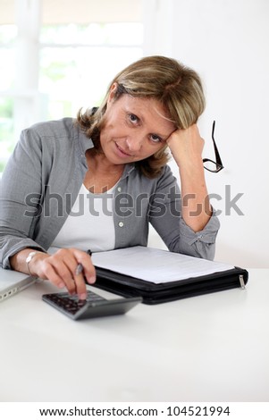 Senior woman pensioner calculating bills