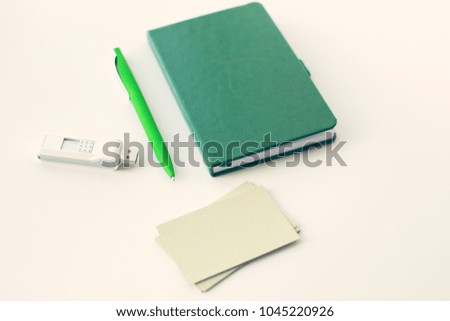 Green pen, notebook, flash drive and empty card
