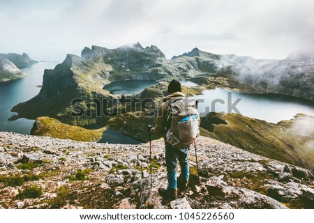 Man hiking in mountains enjoying Norway landscape Travel adventure healthy lifestyle concept active backpacking wanderlust summer vacations outdoor  Royalty-Free Stock Photo #1045226560