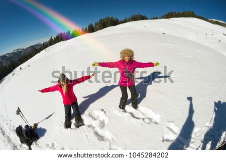 Commercial group of sports girls climbed to the top in the Carpathians and are happy with the beautiful weather taking pictures against the background of the winter observatory