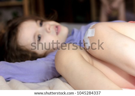 Little kid girl with band on knee