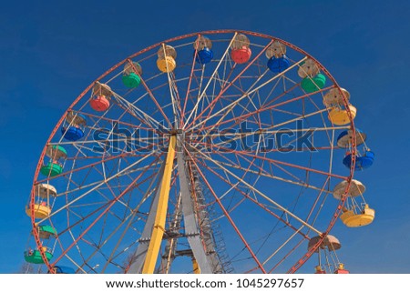 Ferris wheel against the blue sky in the city park
