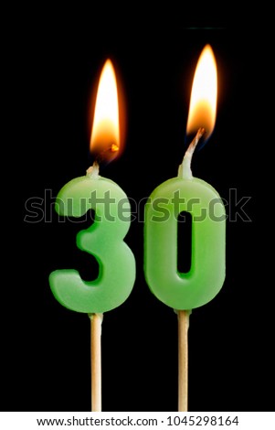 Burning candles in the form of 30 thirty figures (numbers, dates) for cake isolated on black background. The concept of celebrating a birthday, anniversary, important date, holiday