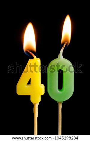 Burning candles in the form of 40 forty figures (numbers, dates) for cake isolated on black background. The concept of celebrating a birthday, anniversary, important date, holiday