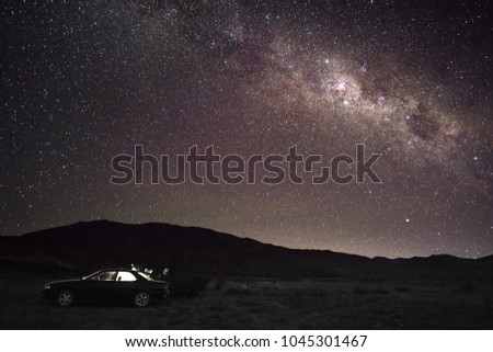 Beautiful scene of Camper travel car with colorful starlight at night on the mountain at Lake Tekapo, South Island, New Zealand,