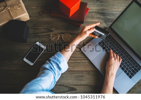 Girl making online shopping and using credit card, waiting for confirmation of online order. Hands holding plastic credit card and using laptop. Online shopping concept. Toned picture. Selective focus