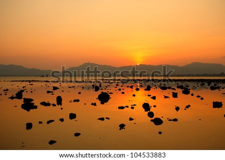 Tropical colorful sunset at the sea with rock, Thailand