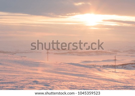 Fire orange and red with yellow colors of sunset evening sky with clouds and mountains on horizon background, picturesque landscape cover wallpaper, sun light beautiful time, snowy hills at winter