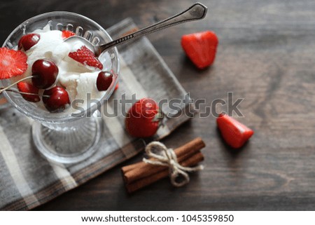 Yoghurt with fresh juicy strawberries and cherries on a wooden table