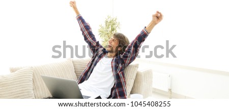 happy young man looking at laptop screen