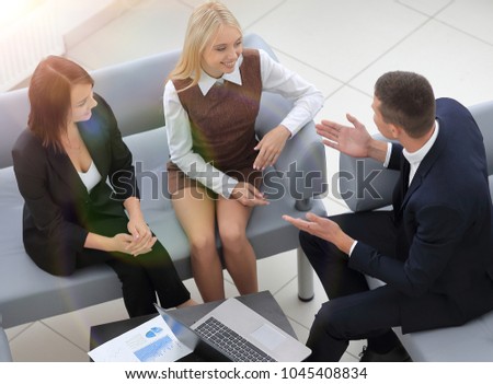 business team discussing financial documents sitting in the lobby of the office