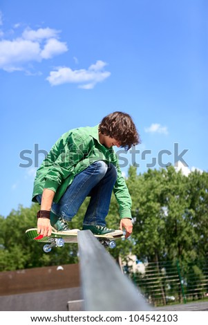 Action shot of a young skateboarder skating against the wall at a skate park.