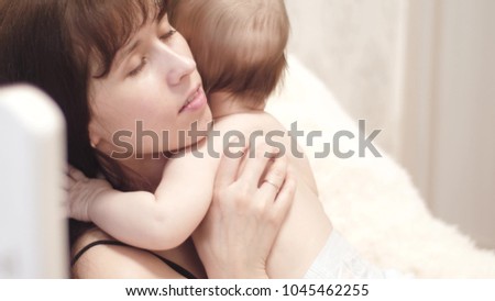 small child plays with her mother at hands of