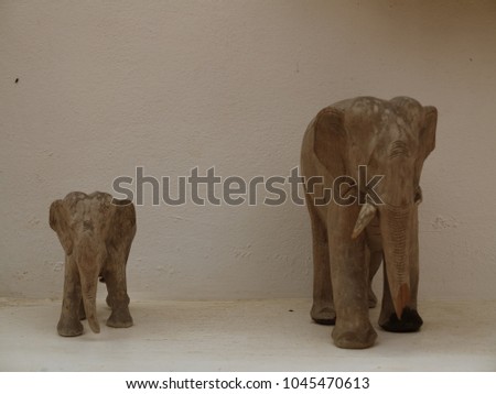 Statue of elephant on a gray mortar background.
