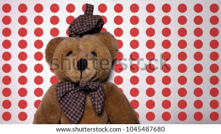 Teddy bear with red polka dots background. portrait of brown teddy bear with blue hat.