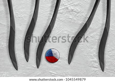 The Czech puck and five sticks on the ice of the hockey arena. Concept, hockey