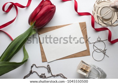 Workspace. Wedding invitation cards, craft envelopes, red tulip flowers and green leaves on white background. Overhead view. Flat lay, top view invitation card. ink pen, ink with copy space. mockup