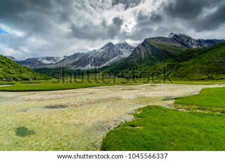 
The muddy grass, under the cloudy sky, in the lake and mountain in the Sichuan Park, China 