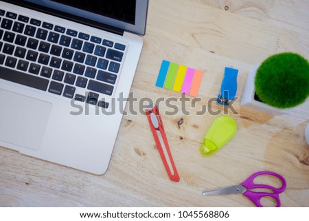 Work space of computer laptop and office supplies on wooden table desk.