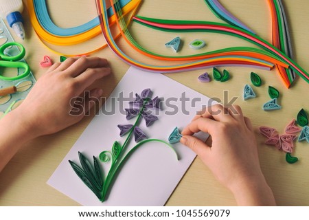 Quilling technique. Making decorations or greeting card. Paper strips, flower, scissors. Handmade crafts on holiday: Birthday, Mother's or Father's Day, March 8, Wedding. Children's DIY concept. Royalty-Free Stock Photo #1045569079