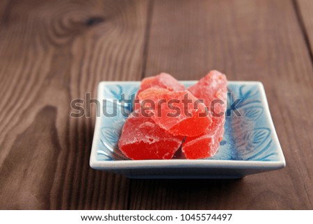 Dry papaya in a plate on a brown wooden background.