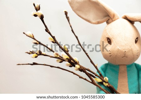 Easter bunny holding a bouquet of willow branches