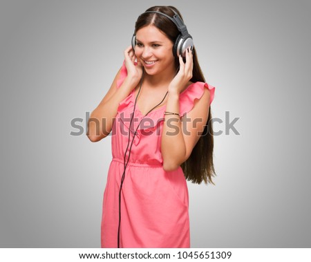 Portrait Of A Young Woman Wearing Headphones against a grey background