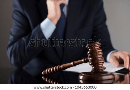 Law concept. Judge, gavel, balance, documents. Gray background. Man in suit.
