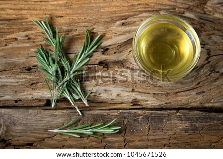 olive oil and rosemary on wooden background