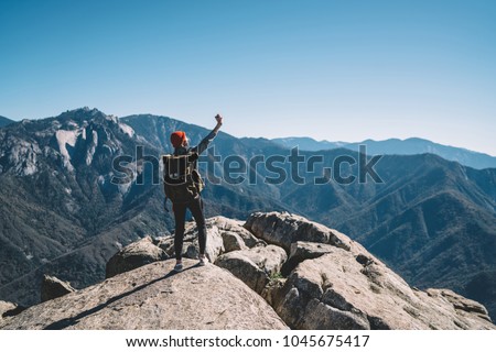 Young female travel blogger making selfie using smartphone on top of mountain on breathtaking scenery, girl wanderlust using telephone for making picture during hiking tour getting to destination