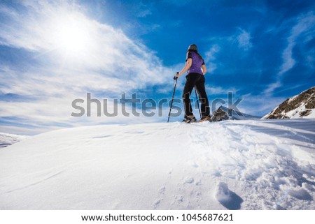 Woman with snowshoes on a mountain top