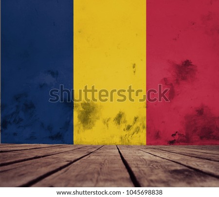 The floor of planks and plastered wall with a painted flag of Republic of Chad.