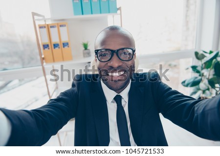 Close up self portrait of stylish, cheerful, attractive man shooting selfie in two hands, smiling at camera, standing in work place, station, having fun, timeout Royalty-Free Stock Photo #1045721533
